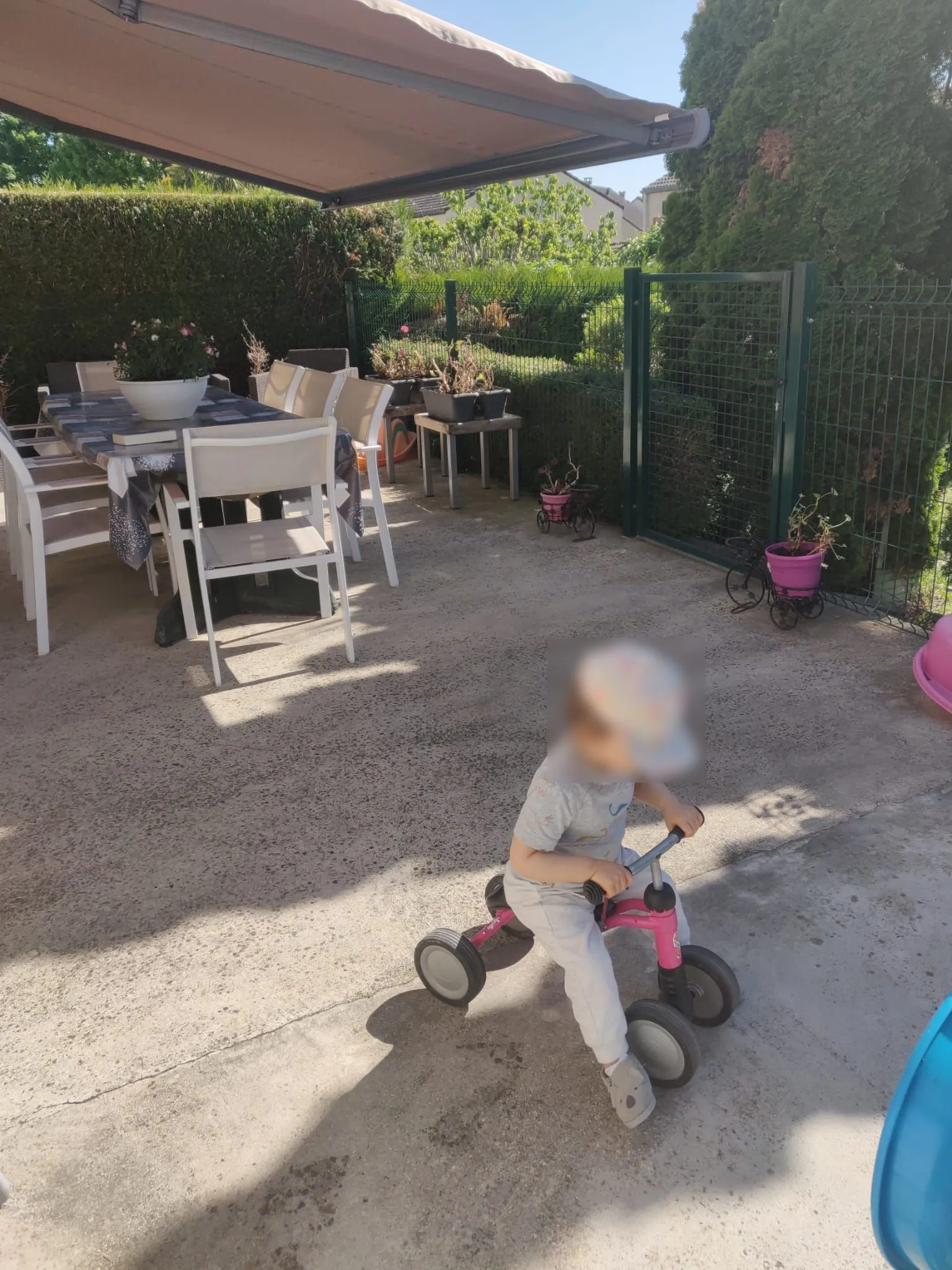 Un enfant sur un porteur joue sur la terrasse sécurisée.